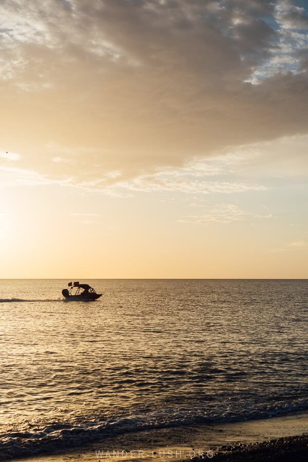 A boat speeds along the Black Sea at sunset off the coast of Anaklia.