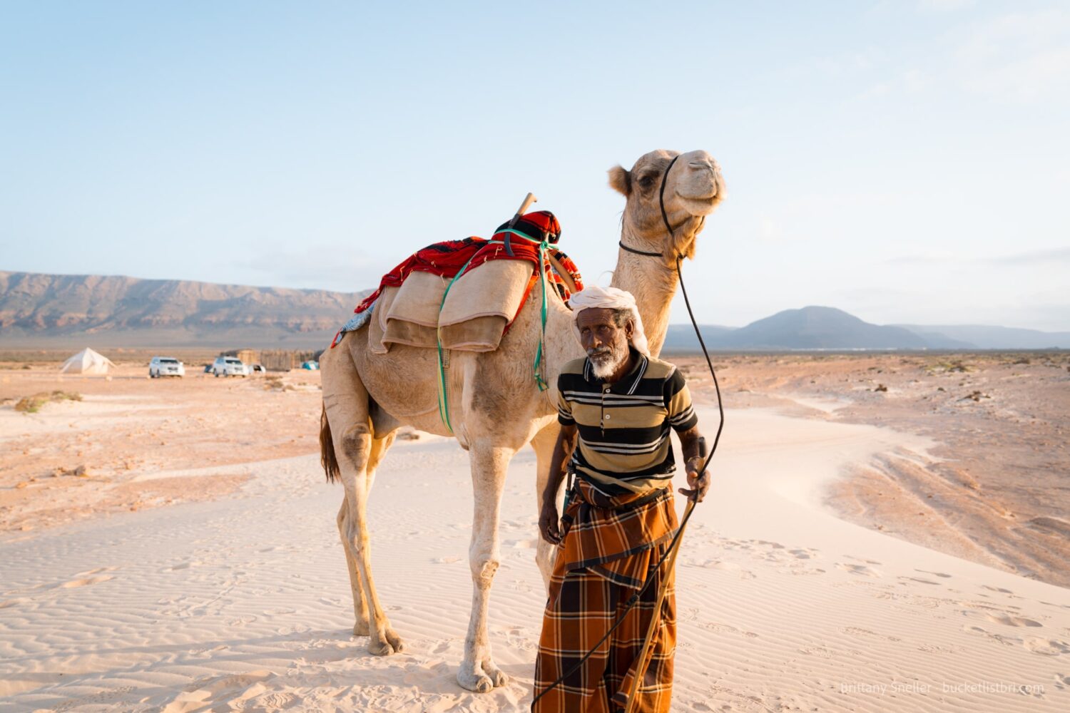 A Soqotri man and his camel on sand dunes, Socotra Island, Yemen.