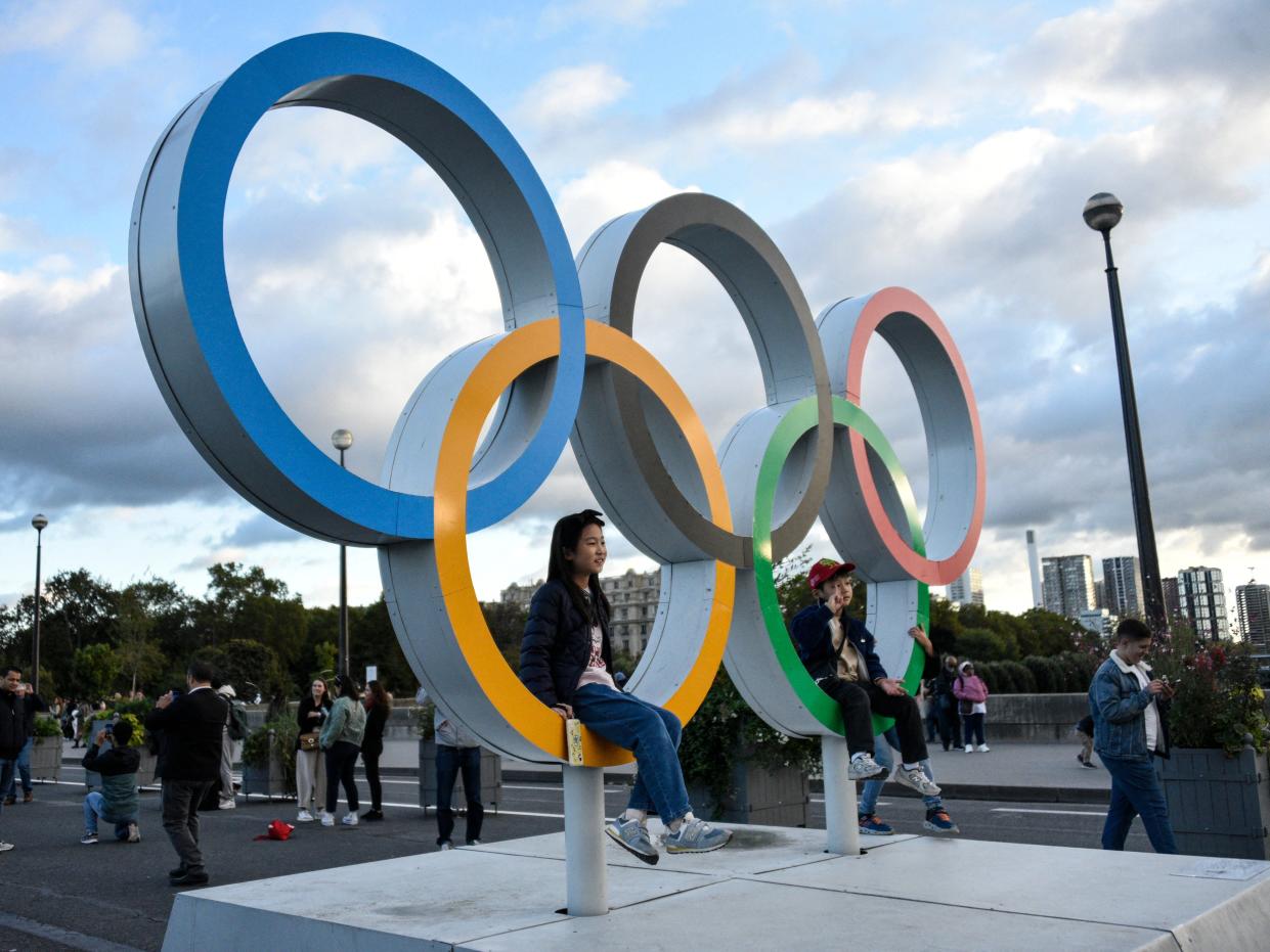 Tourists stroll over the lena Bridge and take photos of themselves with the Olympic Rings in Paris on October 2, 2024.