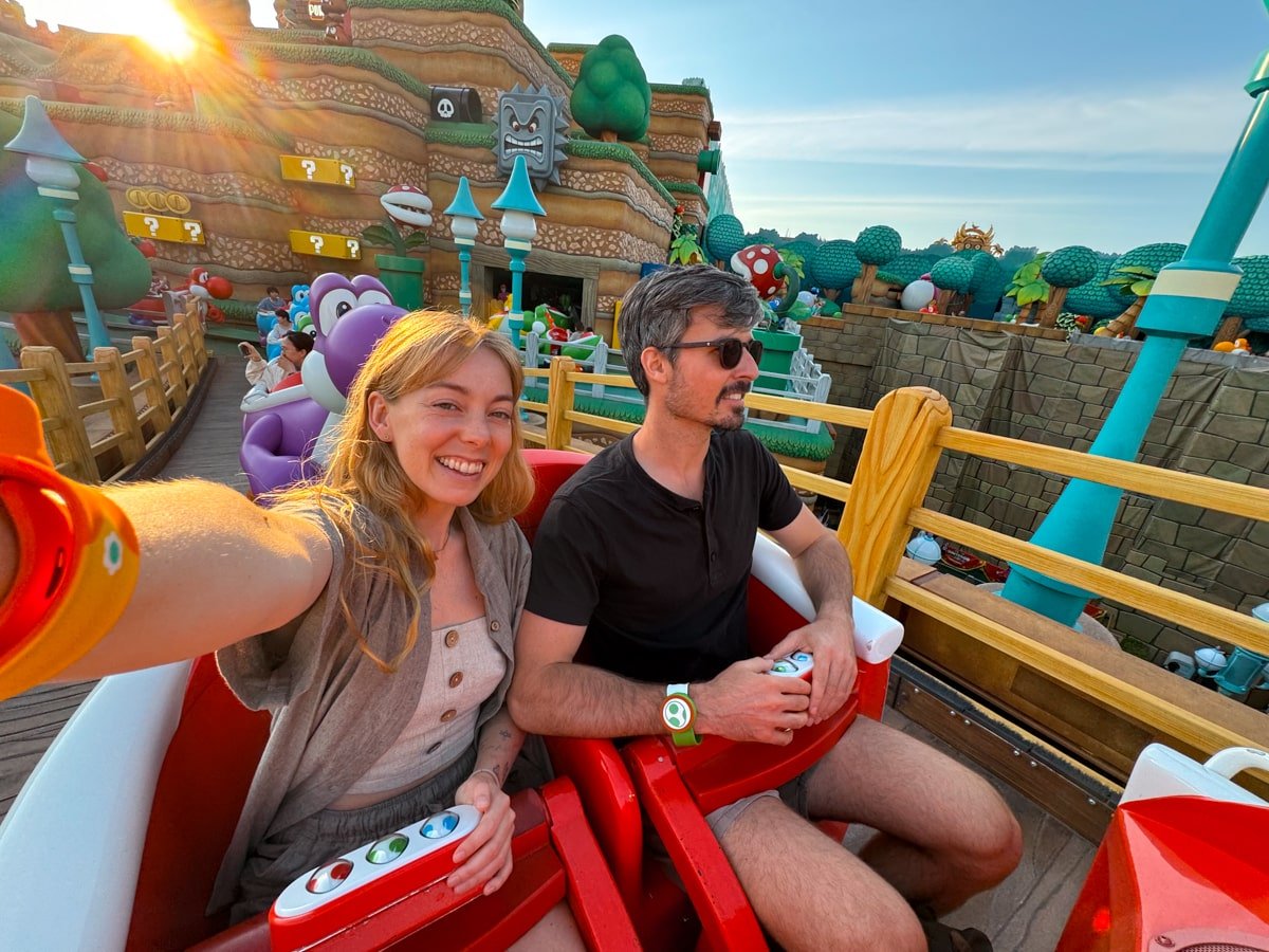 Two adults riding Yoshi's Adventure (slow coaster) inside Super Nintendo World Japan.