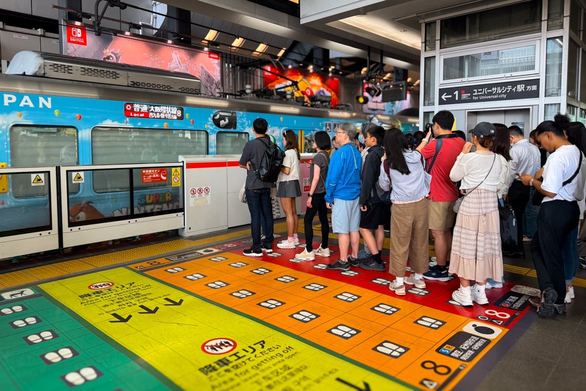 Tourists line up for the Nintendo-themed train arriving at the station to go to Universal Studios Japan.