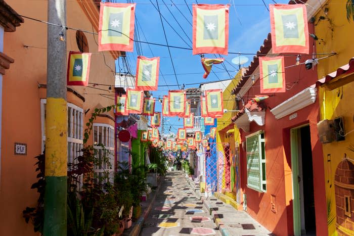 A vibrant street lined with colorful flags and brightly painted houses in&nbsp;Cartagena.