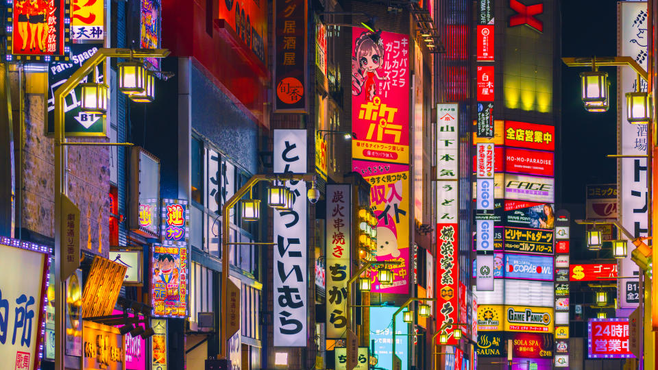 A vibrant city scene with numerous neon signs in Japanese.