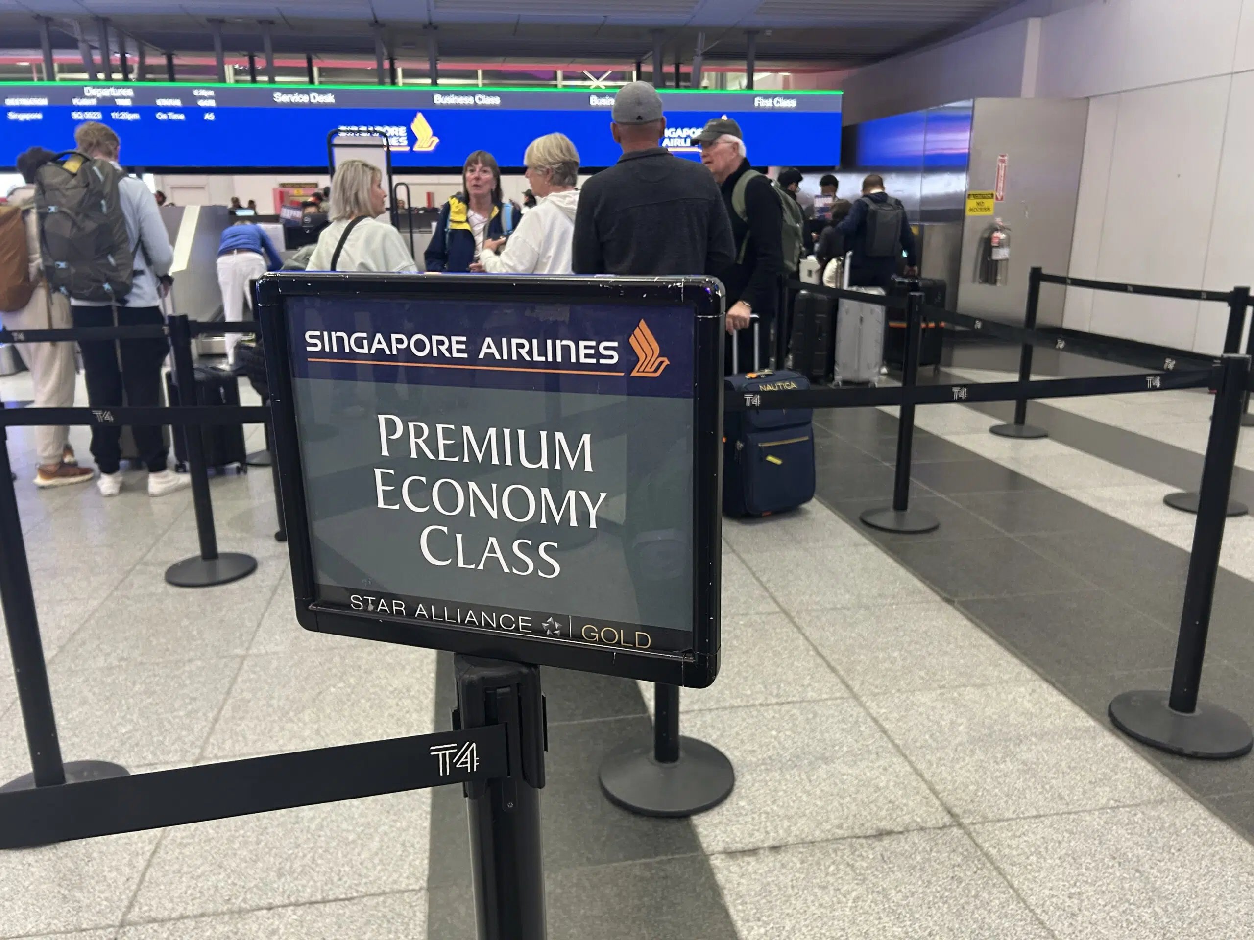 sign and line of people checking in at the airport