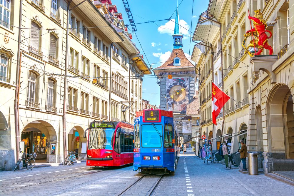 Streets with shopping area and Zytglogge astronomical clock tower in the historic old medieval city centre of Bern.