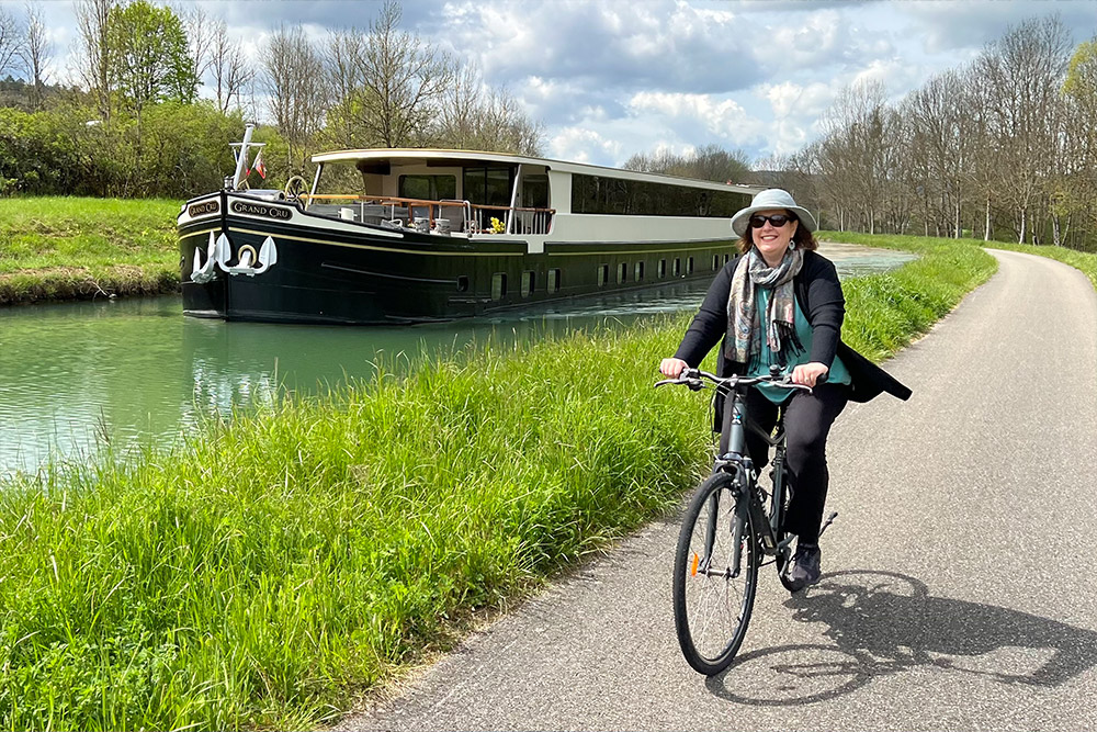 Wendy biking near a barge in the Burgundy canal in France.