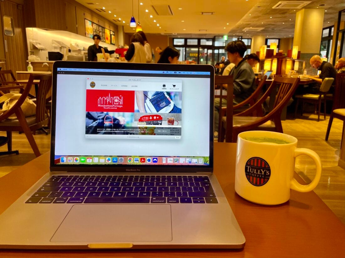 working from a cafe location as a digital nomad, laptop and coffee on table 