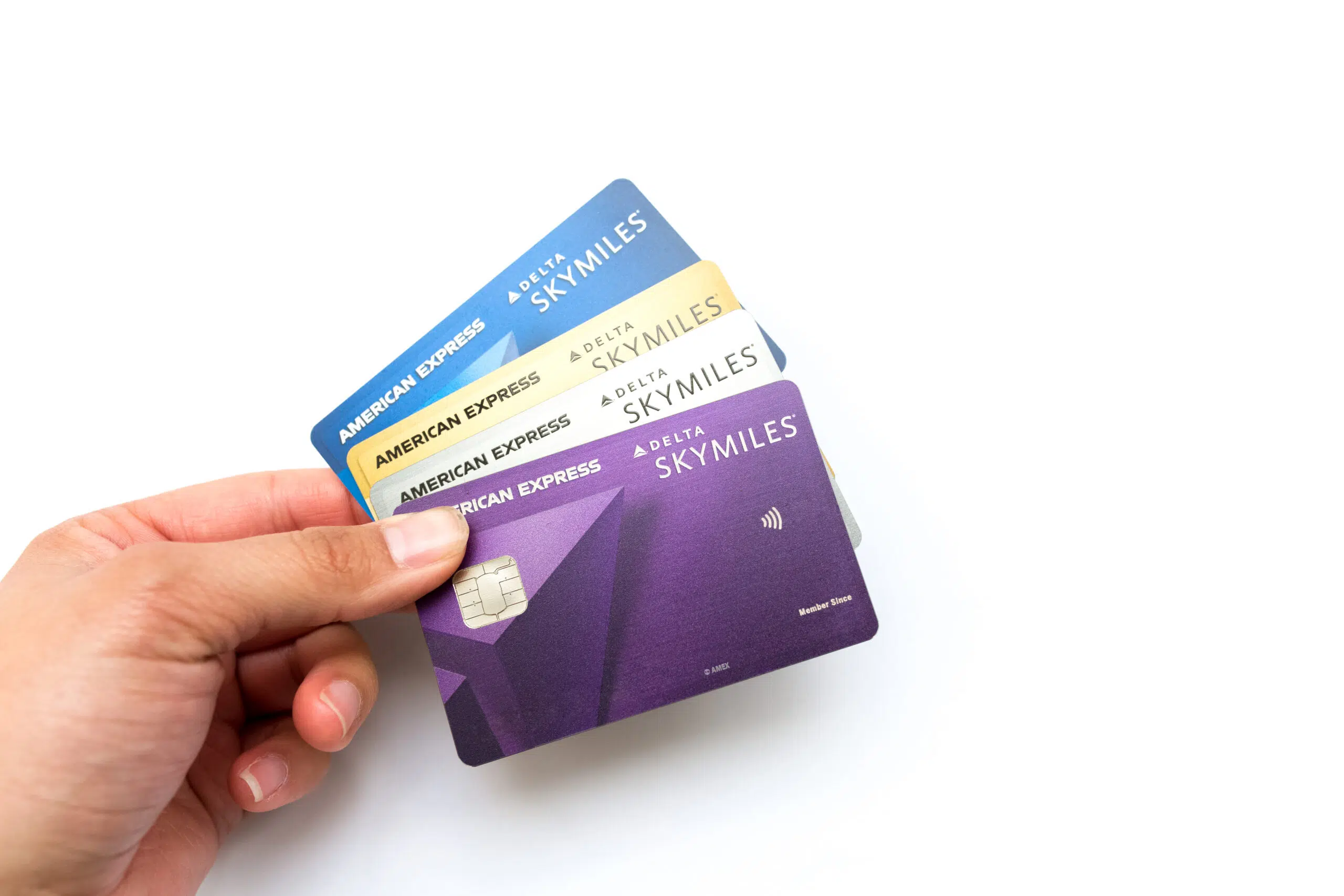 Hand holding four Amex Delta SkyMiles credit cards