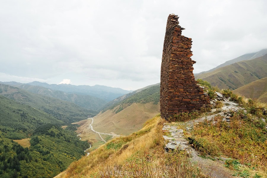 A single brick ruin stands on the edge of a cliff above Ushguli.