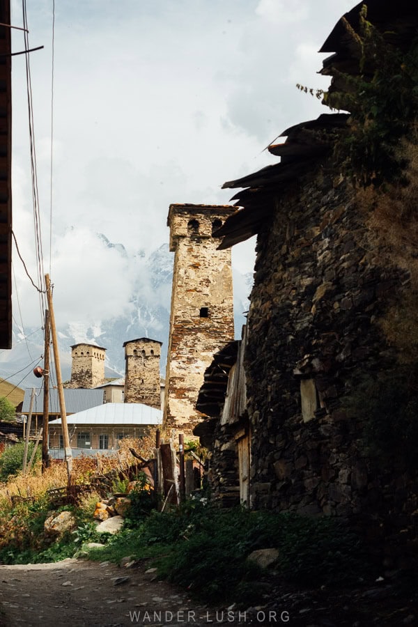 Svaneti towers framed by the ruins of old buildings in Chvibiani, Ushguli.