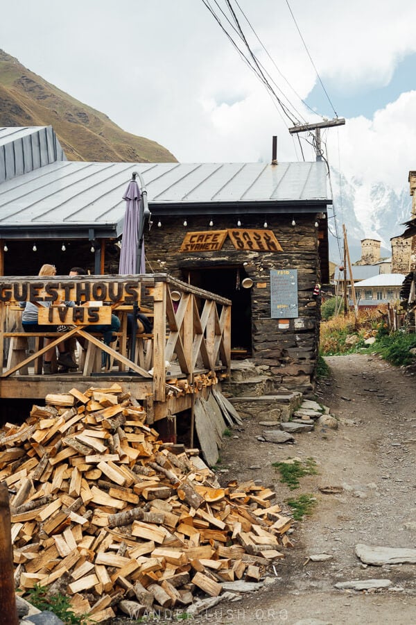 A guesthouse in Ushguli with a pile of firewood at the door.