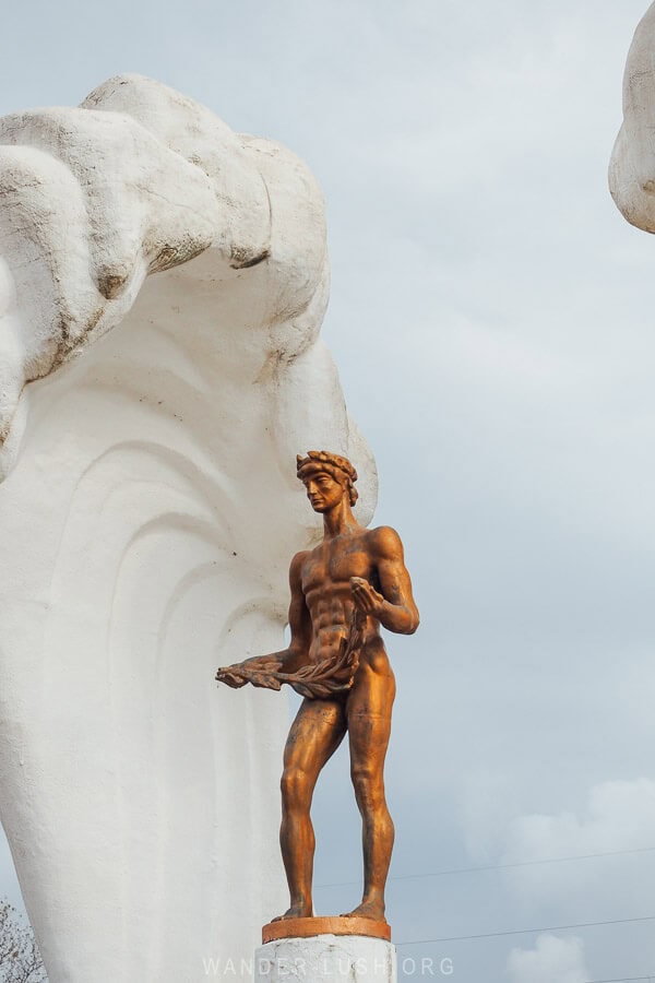 A bronze figure standing atop a column.