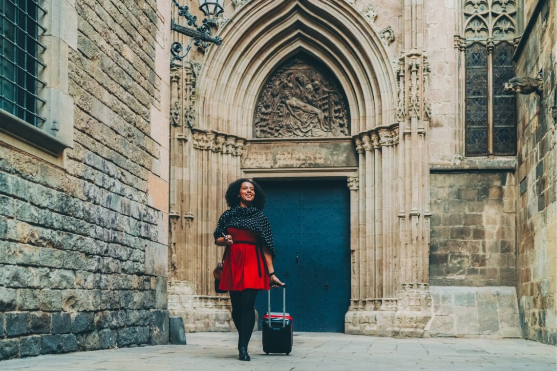 Girl walking with her suitcase in the Gothic neighborhood of Barcelona