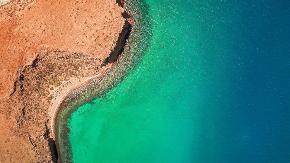 An aerial shot of blue-green waters in Isla del Espiritu Santo, Baja California Sur, Mexico