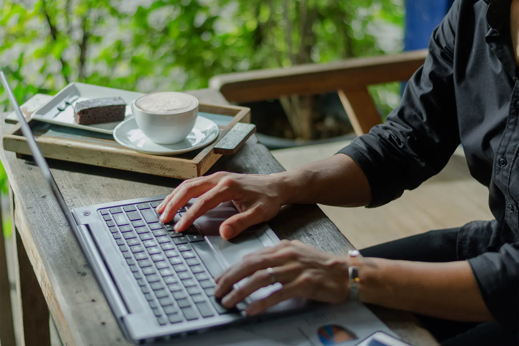 a digital nomad working on his laptop in a tropical location