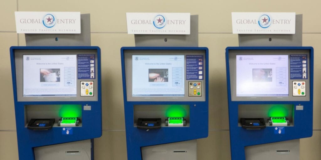 three global entry kiosks along a wall. 