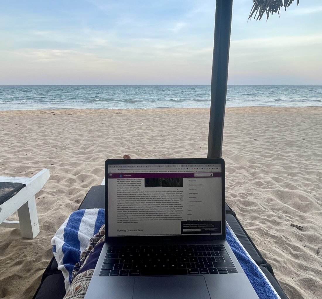 beach scene as a digital nomad, laptop on deck chair 