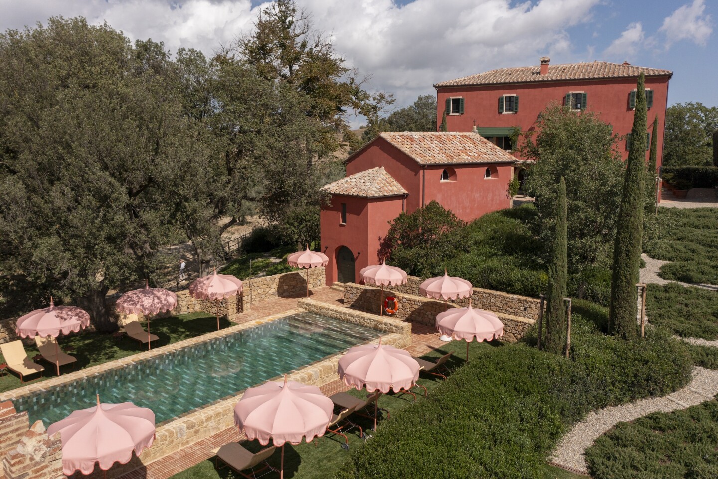 Casa Newton has a large pool flanked by lounge chairs with pink umbrellas