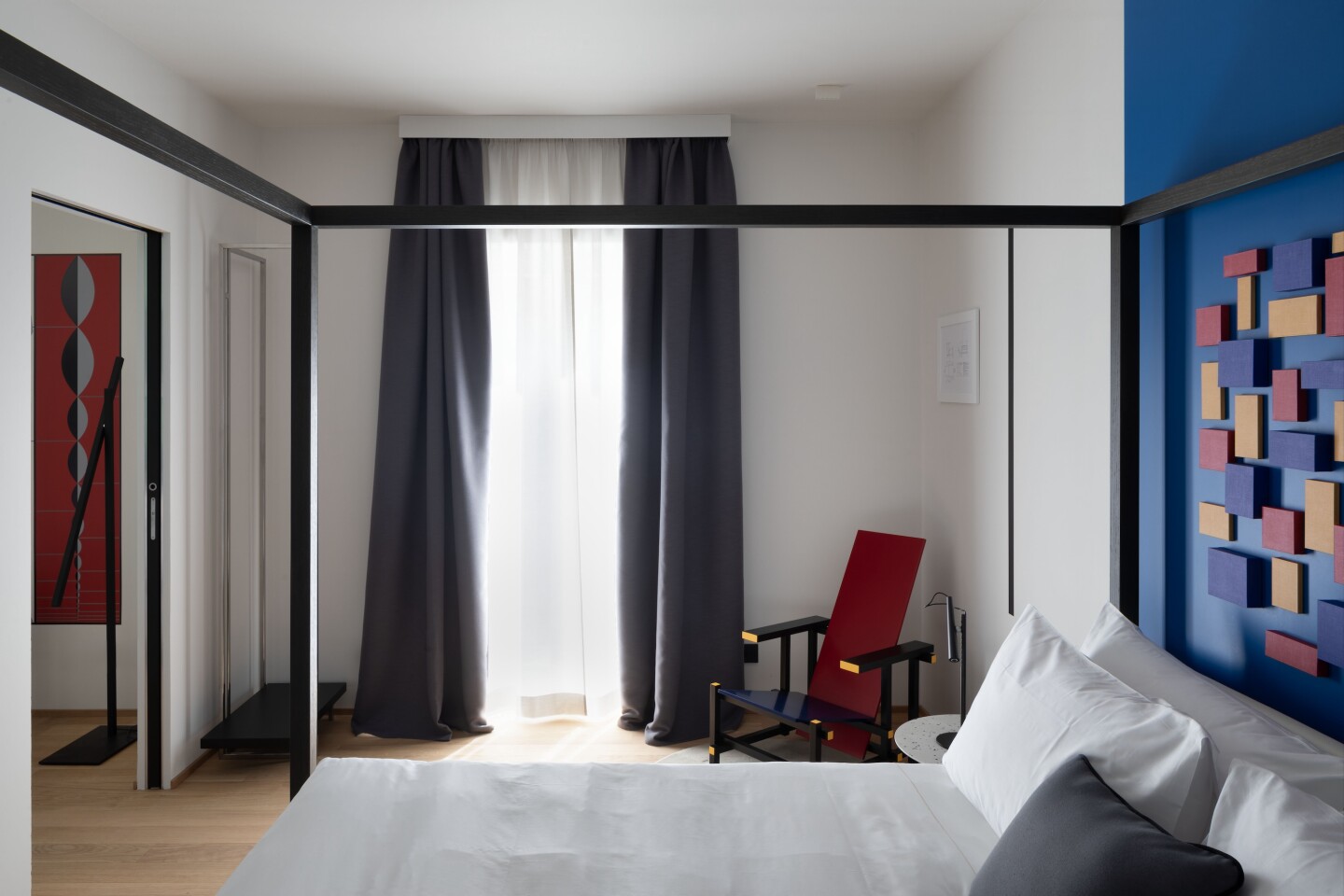 A guest room at Hotel Interno Marche with a blue wall and a four-poster bed