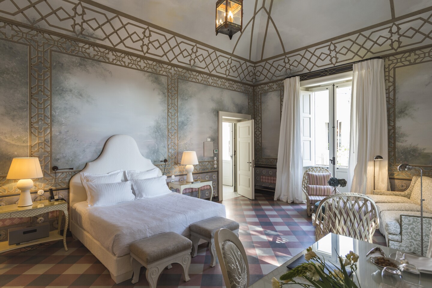 The Sofia suite features gauzy white floor-to-ceiling curtains, a white bed, and painted walls.