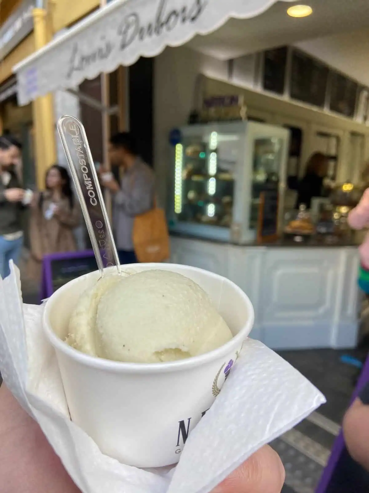 Riana holding a cup of ice cream in front of an ice cream parlour in Nice, South of France