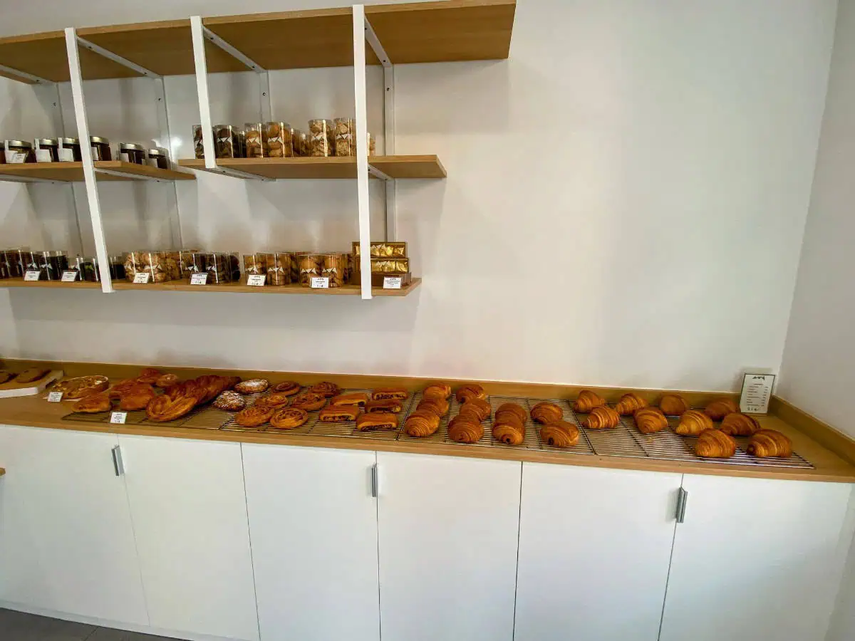 A bakery in Menton, France with a row of croissants and other baked goods