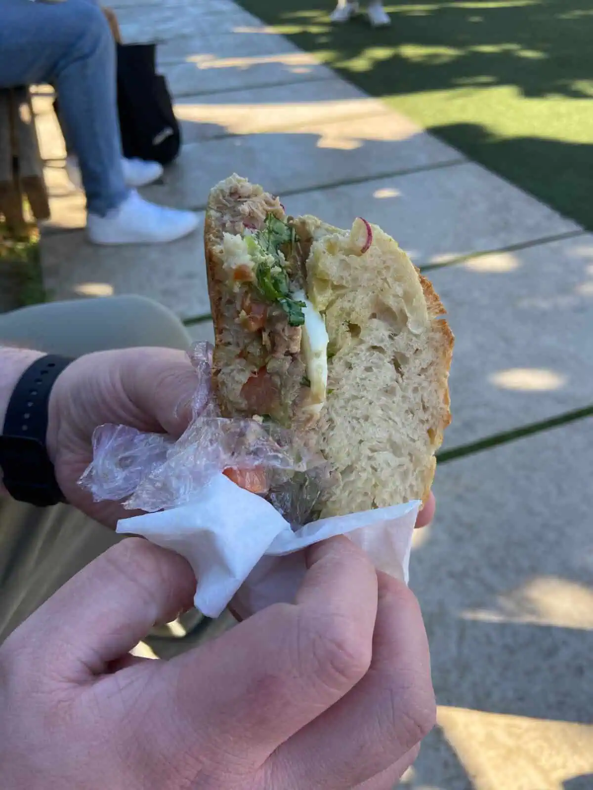 Colin holding a Pan Bagnat sandwich in Nice, France