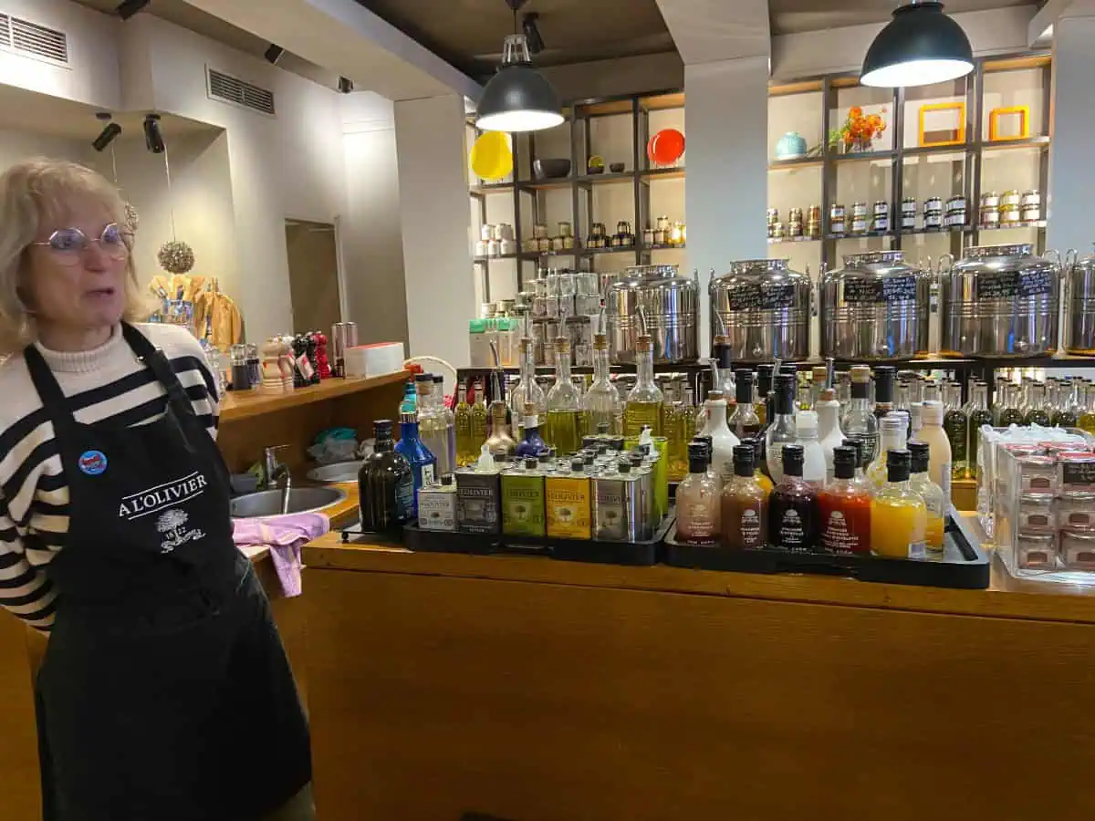 Olive oil tasting during a food tour in Nice; a line of olive oils is set on a counter with a shopkeeper next to them