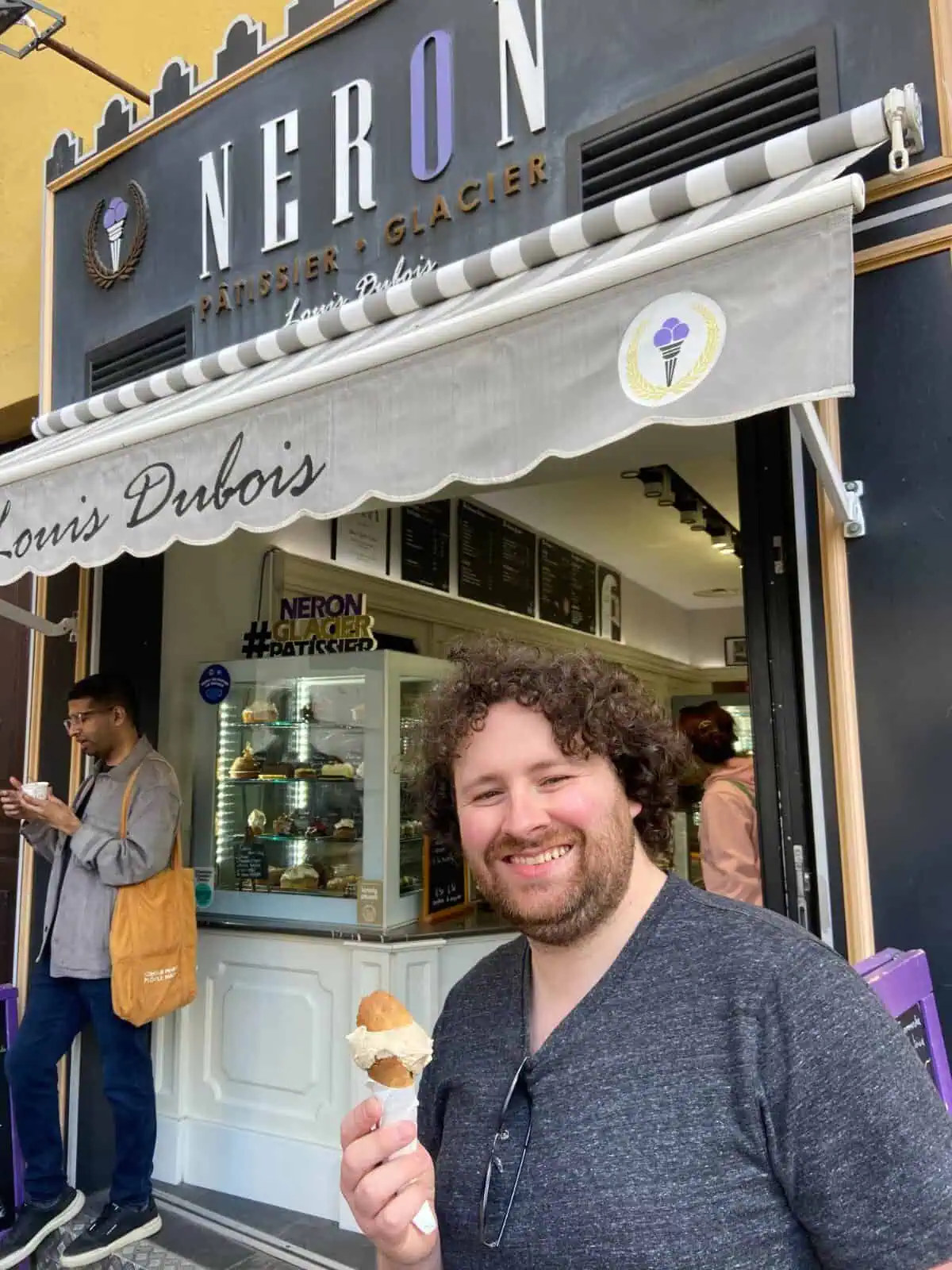 Colin smiling with an ice cream cone outside of an ice cream store in Nice, French Riviera