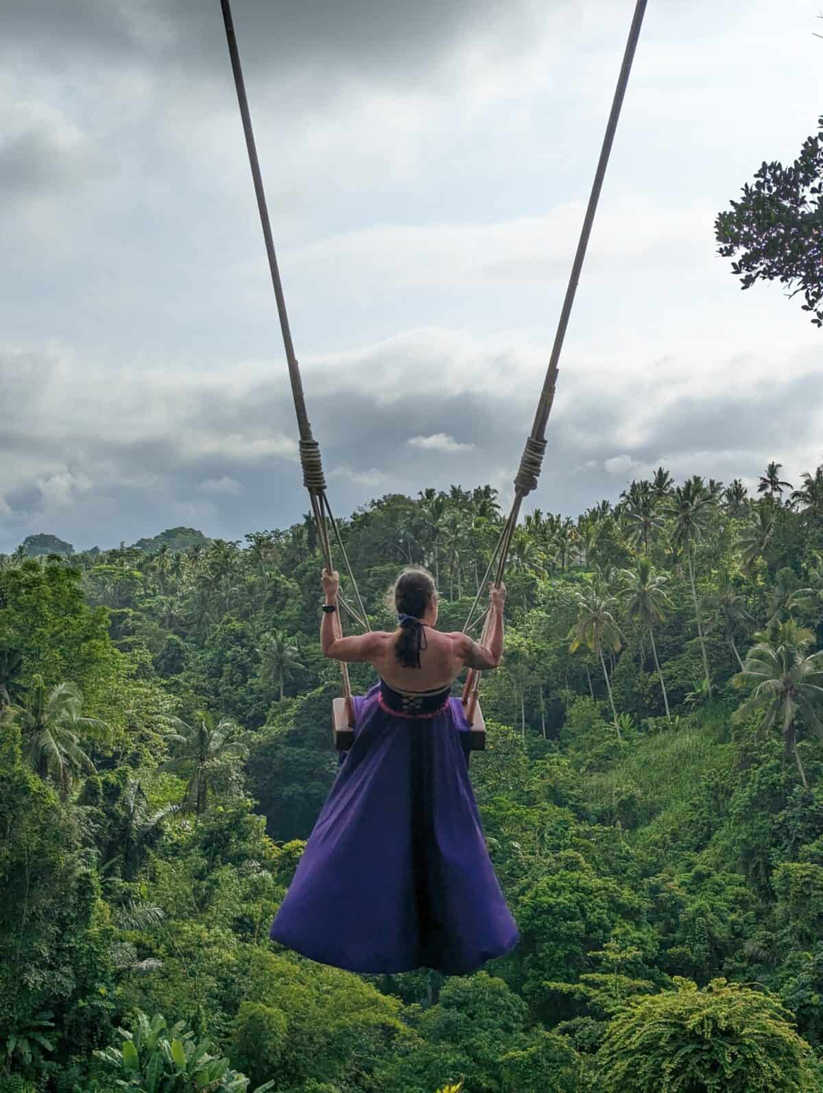 Lyn on a swing in Bali, Indonesia over a lush green field