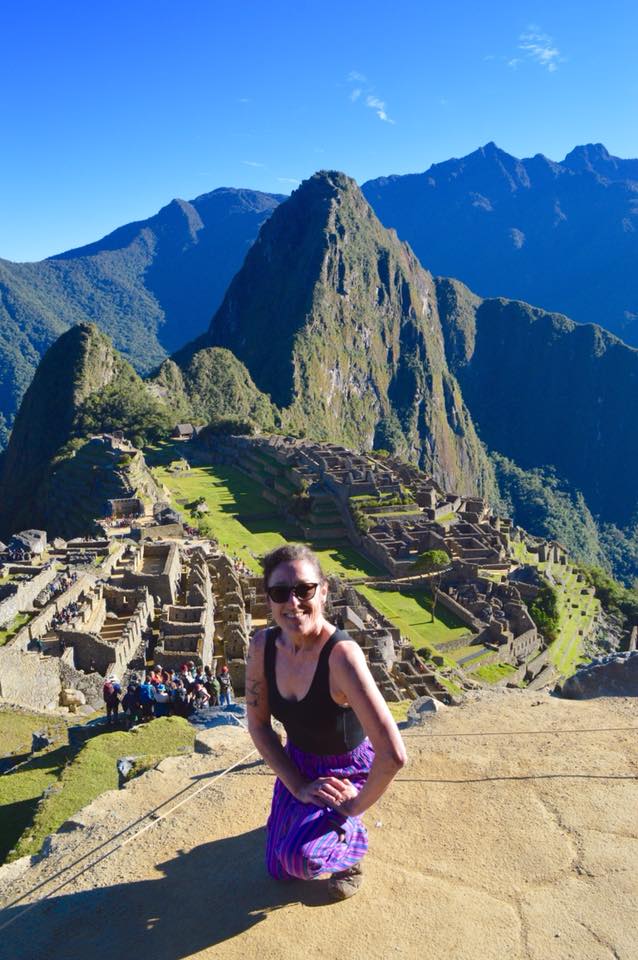 Lyn kneeling in front of Machu Picchu, Peru at sunrise