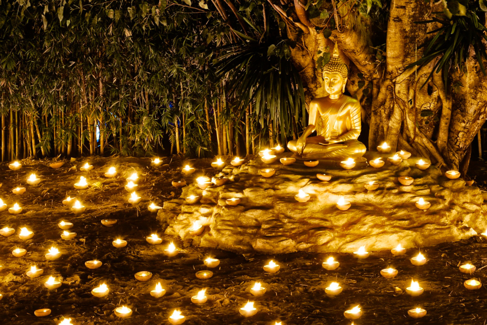 Buddha lightened up by candles in Bangkok, Thailand.