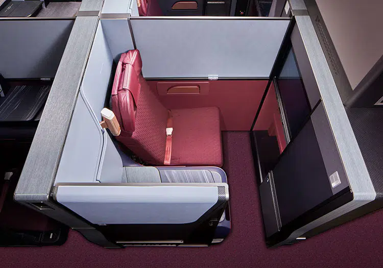 business class suite on a plane with red seating