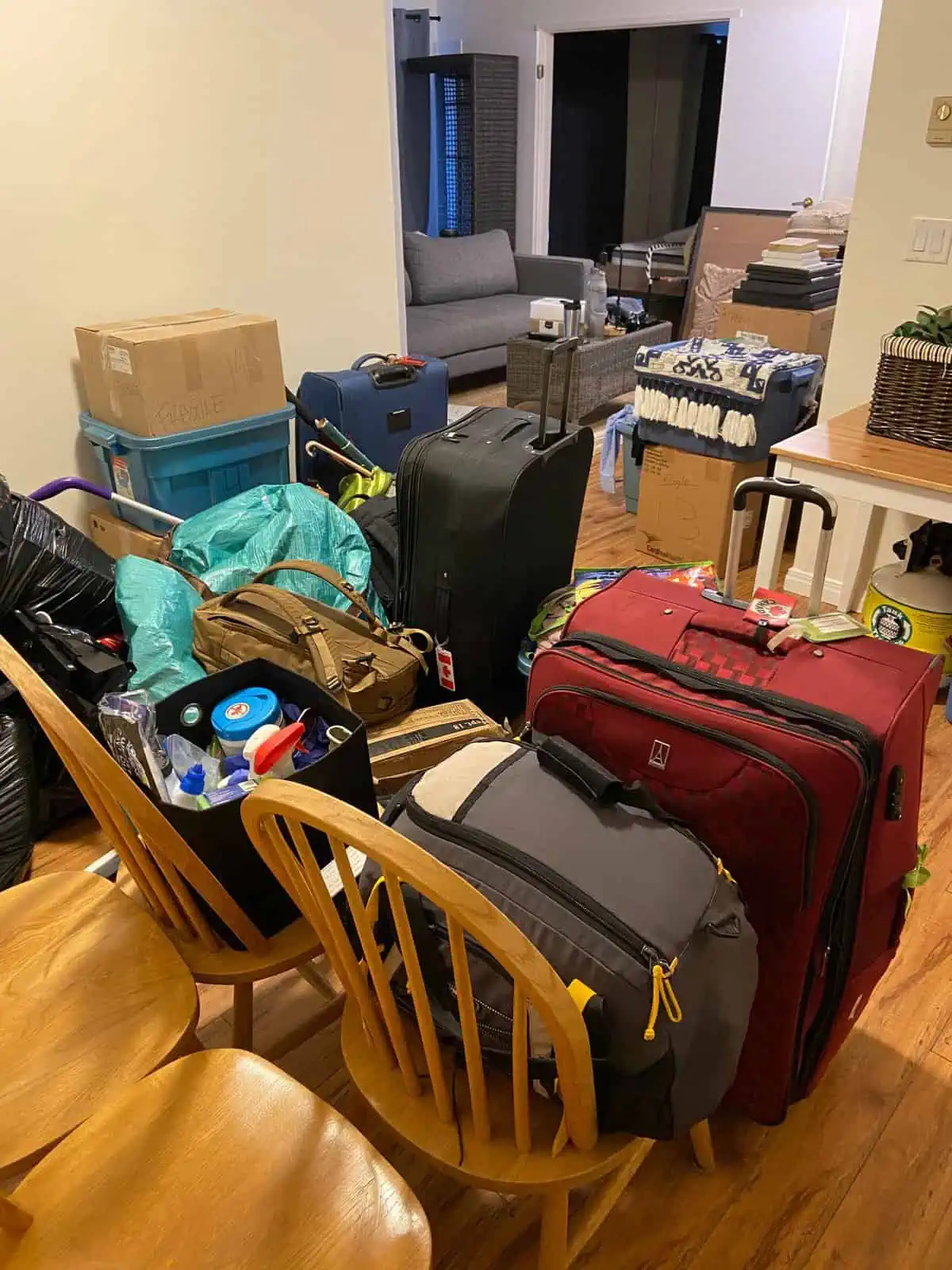 suitcases and duffel bags all piled up in the dining room for moving house