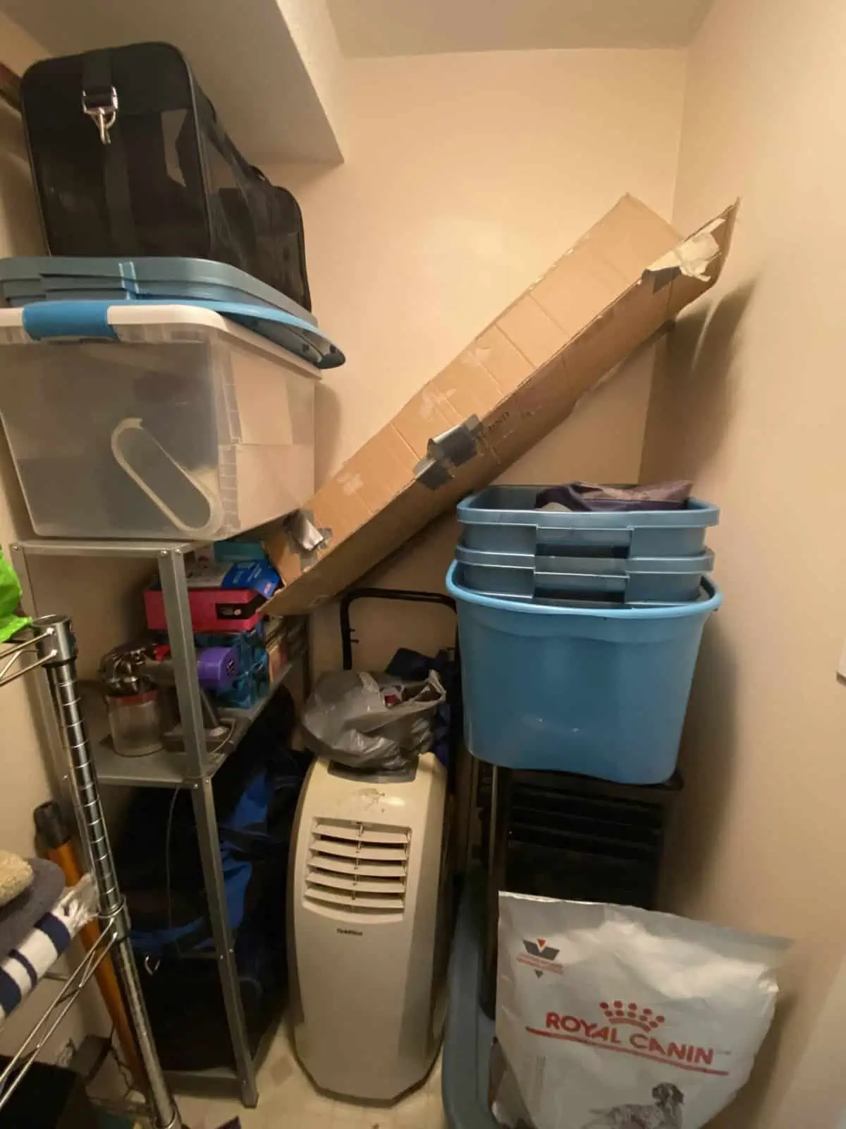 storage closet in yaletown apartment piled with boxes, bins and an air conditioning unit