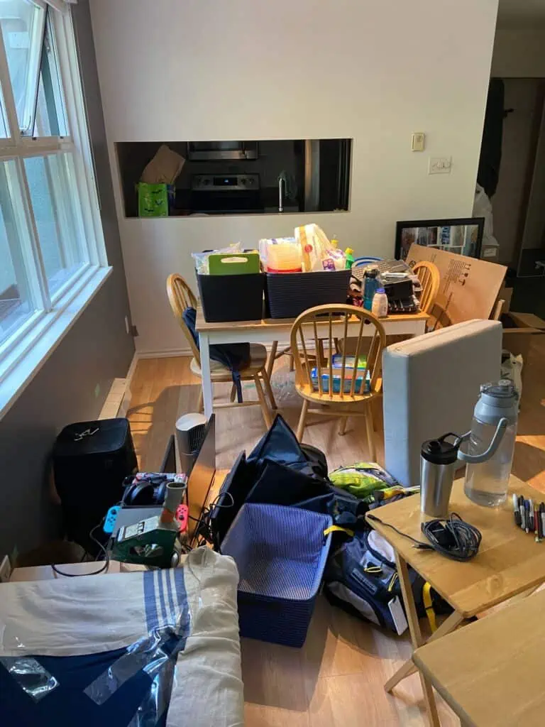 Living room and dining room table covered in items that are being packed for a move, packing and moving tips for moving house