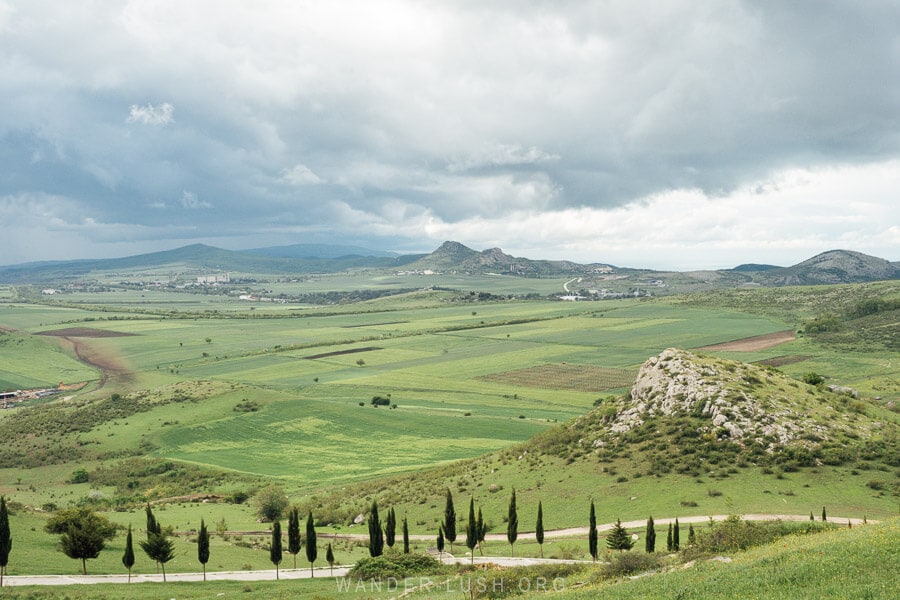 A green landscape of hills with a limestone mountain peak in the distance, viewed from St Elia Monastery outside Dedoplistskaro, Georgia.