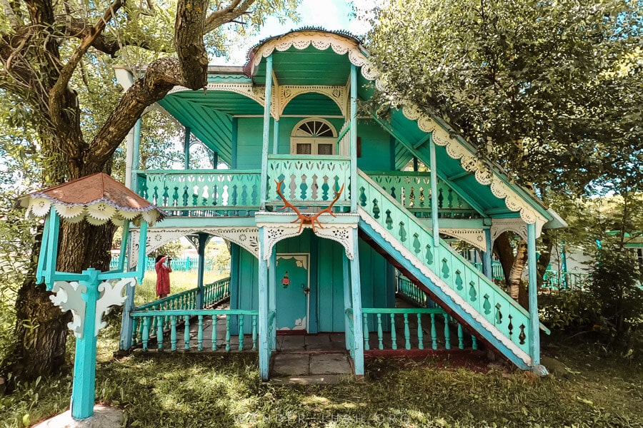 A blue and white house with decorative woodwork in the village of Gorelovka, one of the most unique places to visit in Georgia country.