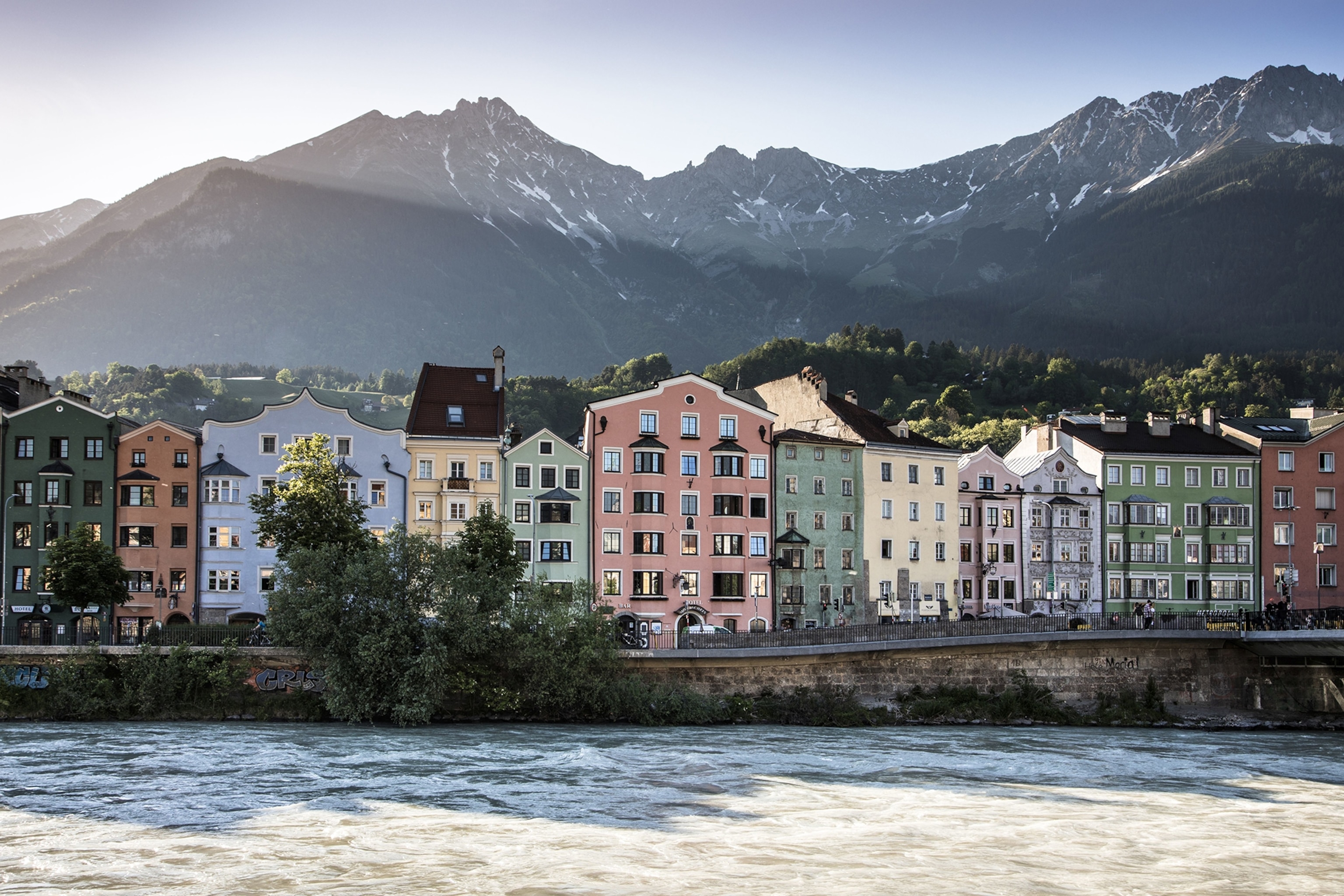 Colourful traditional Austrian buildings with a mountain backdrop.