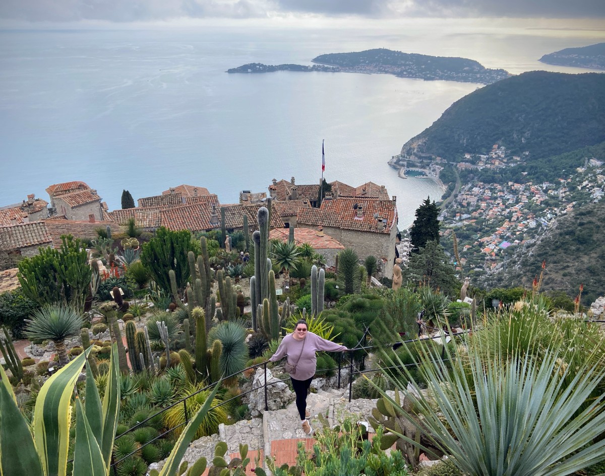 Riana posing in the Eze Jardin Exotique with views of the village and ocean below her