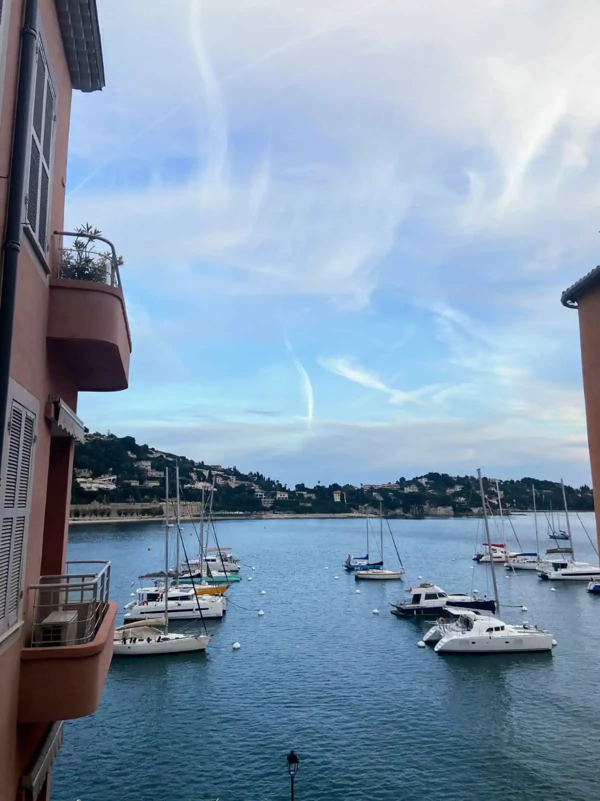 Boats in the harbour of Villefranche sur Mer as seen through the gaps between buildings