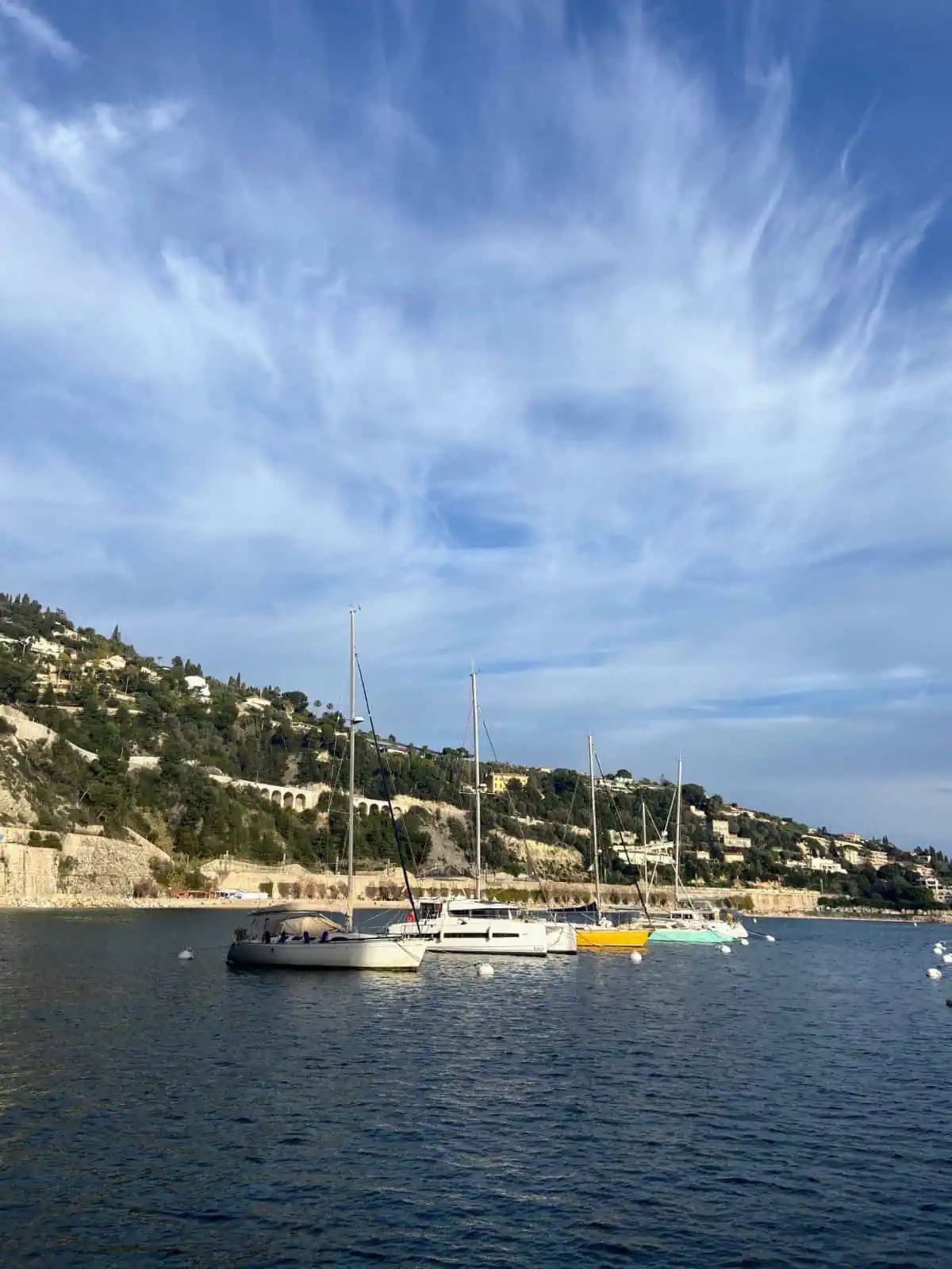 Sloping hill and boats in the water in Villefranche-sur-Mer, Cote d'Azur, France