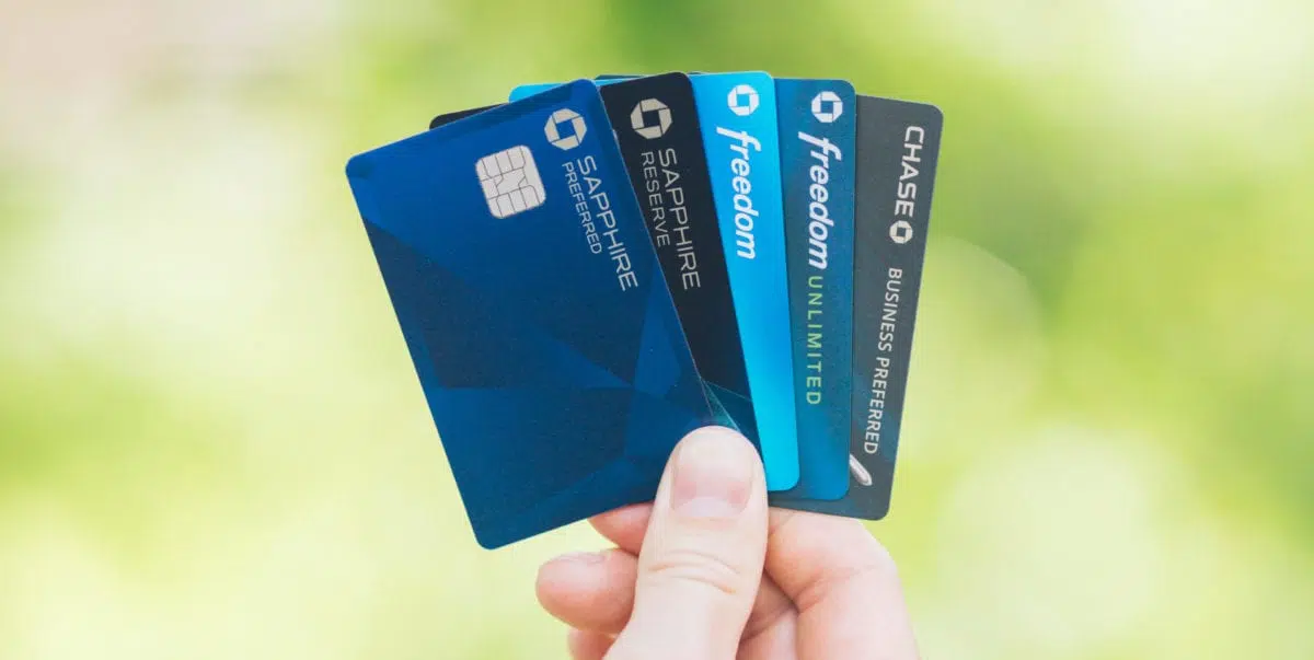 A hand holding up five Chase credit cards 