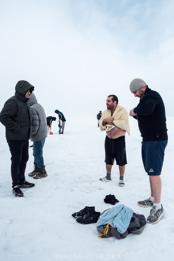 Three men stand on the frozen Paravani Lake in Javakheti, Georgia.