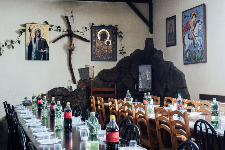 Wooden tables set with plastic plates and bottles of water and soda for an Epiphany feast at Poka St Nino Monastery in Georgia.