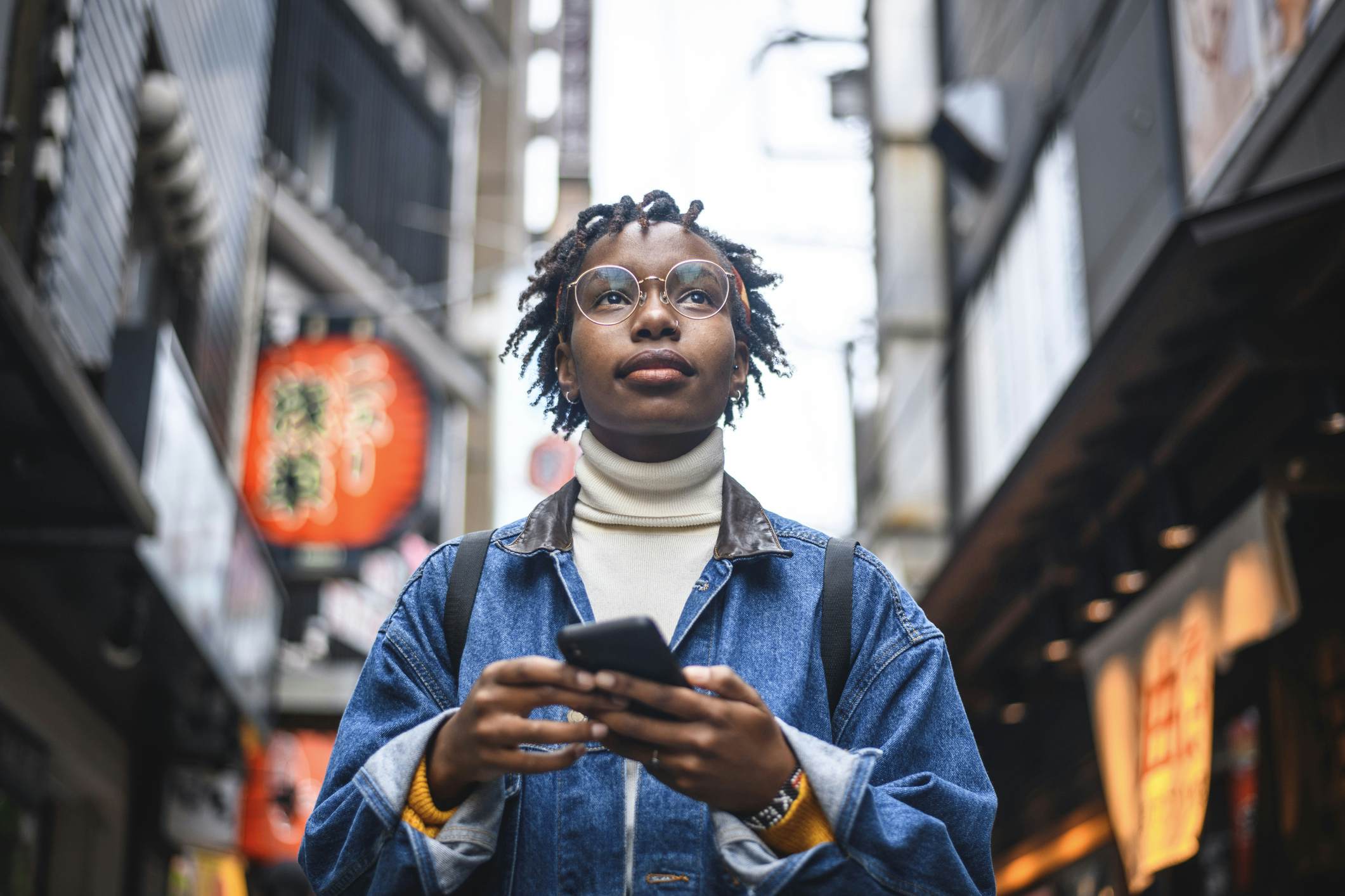 A young Black woman using her smartphone on the street in Tokyo, Japan