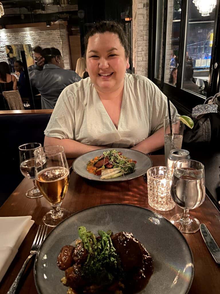 Where to Eat in Yaletown, Vancouver 19 Riana in front of two plates of food on the table at Brix & Mortar, Yaletown, Vancouver