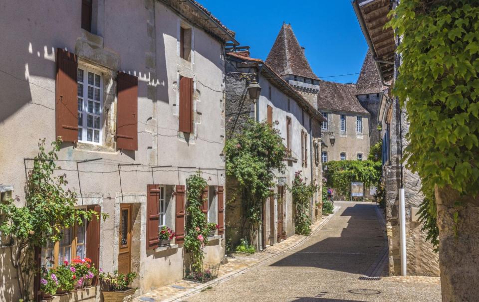 france, dordogne, perigord vert, saint jean de cole plus beau village de france most beautiful village in france, peasant houses with flowers along the street