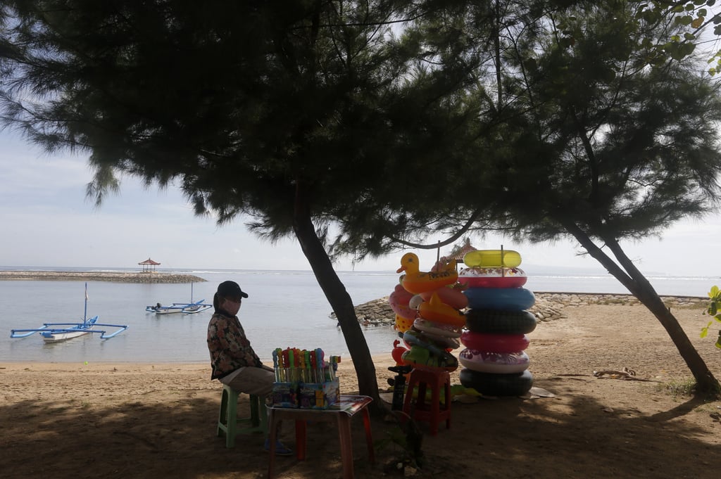 A vendor wears a face mask while she waits for costumers in Bali, Indonesia. Photo: AP